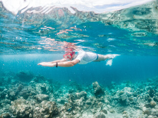 woman snorkeling in clear tropical sea