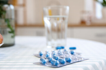 Folic Acid pills on dining table in kitchen, closeup