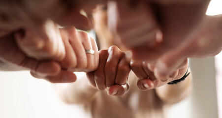 Business team spirit in close-up view from above, showcasing fists in high five gesture. Unity,...