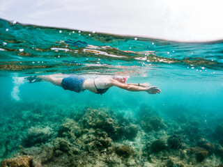 woman snorkeling in clear tropical sea