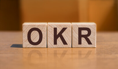 text OKR - Objectives and Key Results - written on wooden cubes