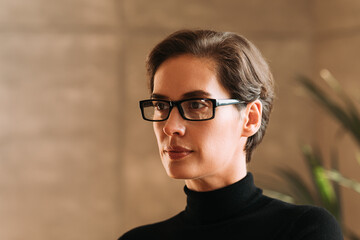 Fototapeta na wymiar Portrait of a confident Caucasian businesswoman in eyeglasses looking away