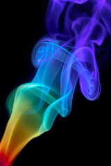 Obraz premium Colorful rainbow swirly incense smoke under prism light flowing upward inside dark studio