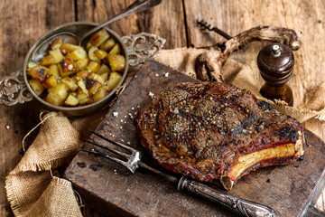 côte de boeuf entière sur un billot avec sa fourchette à viande; photo réelle