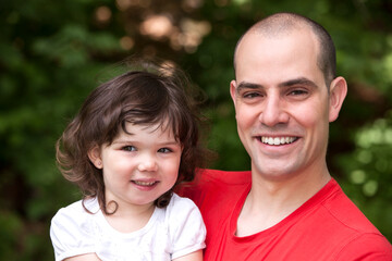  Portrait of father with young daughter outdoors.