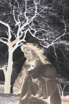 A statue of a sad angel in a bright glowing film negative.