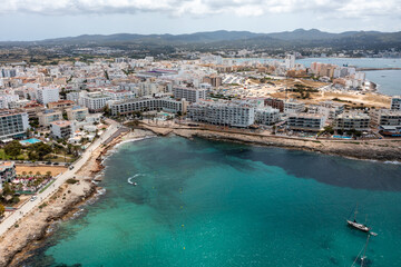 Aerial drone photo of a beach in the town of Sant Antoni de Portmany on the island of Ibiza Balearic Islands Spain showing the ocean front and Cala Alto de Porta beach in the summer time.