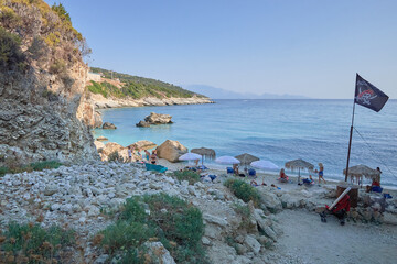 Kamienista plaża z parasolami i widok na morze i linię brzegową