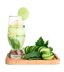 Board and glass of infused water with cucumber slices on white background