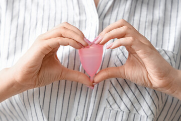 Young woman with menstrual cup in bedroom, closeup