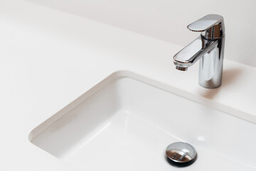 white modern sink and chrome faucet in bathroom