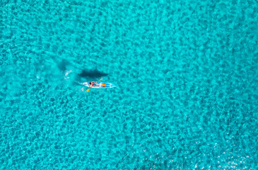 Aerial view of kayak in blue sea at summer sunny day. Man on floating canoe in ocean with...