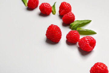 Fresh raspberries and mint on grey background