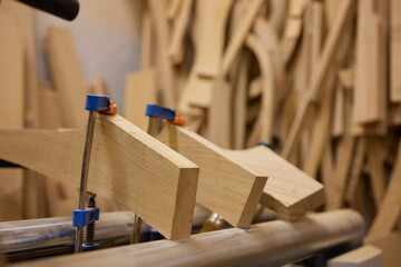 close up of a carpenter screwed a hinge on a wooden plank.