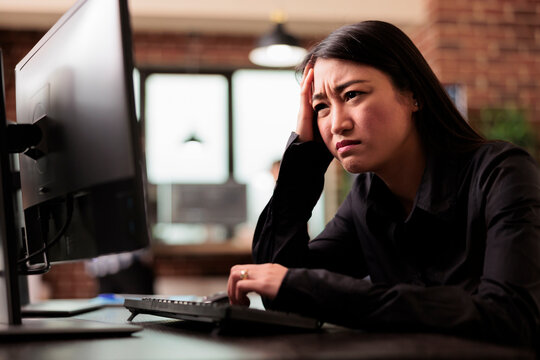 Tired tech engineer was struggling to keep up with the demands of the software development project, feeling the stress of overwork. Coder writing ai algorithm and sitting at desk in it company.