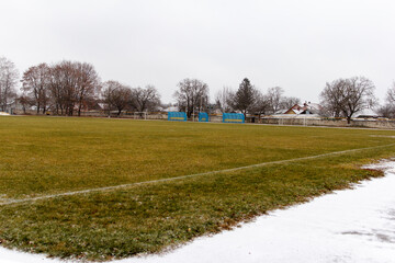 Fototapeta premium Review of sports stadium. A large football field covered with grass, with gates and stands for referees