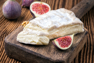 Traditional French soft cheese brie and figs served  as close-up on a rustic wooden design board