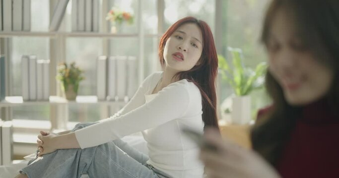 Roommate concept of 4k Resolution. Asian woman is upset because girlfriend is not interested in the house. She is addicted to the game and has no interest in her surroundings.