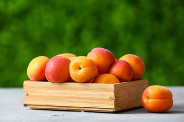 Wooden box with fresh apricots on table outdoors