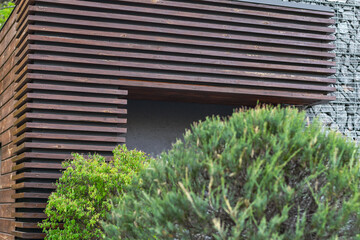 Fragment of slatted wood panels used in the exterior wall outdoors. Selective focus.  - obrazy, fototapety, plakaty