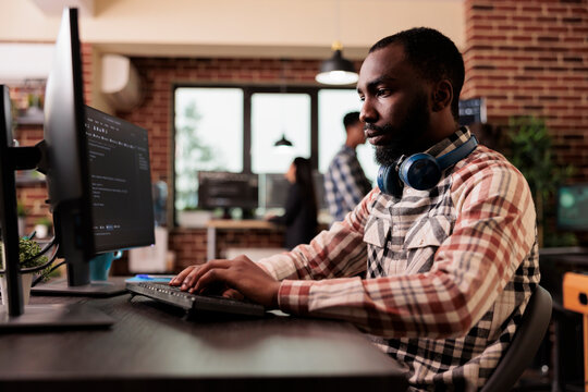 Freelance coder typing javascript code on computer to develop online cloud computing information. Software developer writing html script and data algorithm, working in it programming office