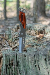 one very beautiful modern iron compact with a brown handle a sharp knife sticks out in an old...