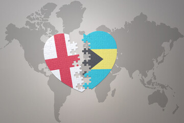 puzzle heart with the national flag of bahamas and england on a world map background.Concept.