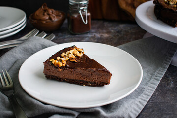 Slice of Chocolate Hazelnut Mousse Cake on a Plate: Dark chocolate and hazelnut mousse pie on a white plate with a fork