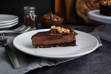 Slice of Chocolate Hazelnut Mousse Cake on a Plate: Dark chocolate and hazelnut mousse pie on a white plate with a fork