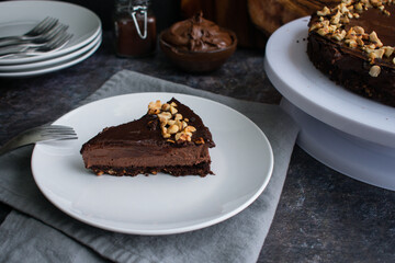 Slice of Chocolate Hazelnut Mousse Cake on a Plate: Dark chocolate and hazelnut mousse pie on a white plate with a fork