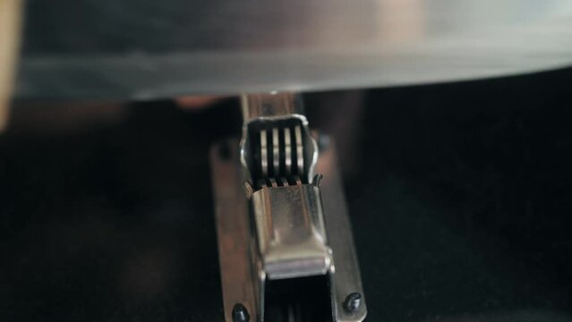 Man Sharpening the knife with a whetstone on a wooden background close up.