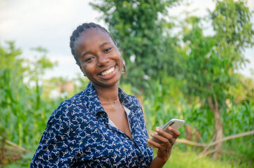 female african farmer using her phone. african farmer checks her mobile phone, texts and chat