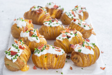 baked potato stuffed with cheese, bacon and sour cream. loaded hasselback potatoes