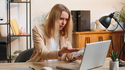 Stressed businesswoman working looking at unpaid bank debt bills, analyzing paperwork, planning budget, calculate finances mortgage payments at office. Displeased freelancer woman throws paper bills