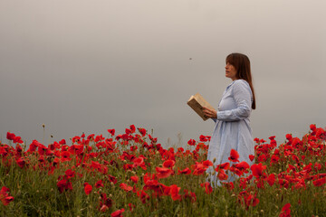 Mujer leyendo en campo de amapolas
