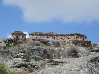 Fototapeta premium Marcahuasi chullpas, house made with stones on the top of a rocky mountain, archaeological remains in the mountains with a background of blue sky in South America