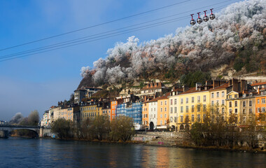 View of right bank of Isere river in Grenoble with cable car to Bastille, France