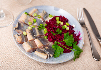 Fototapeta Appetizing pieces of lightly salted herring served with beetroot salad on plate obraz