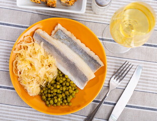 Fototapeta Delicious filets of lightly salted Atlantic herring garnished with shredded marinated cabbage and pickled green peas served as appetizer obraz