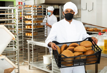 Fototapeta Portrait of baker in protective mask in bakery kitchen obraz