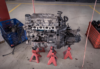 a set of car engines and transmissions that are being removed and will be repaired in a garage