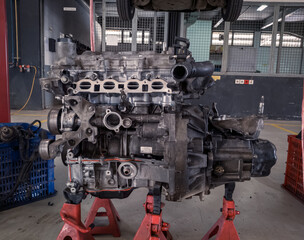 a set of car engines and transmissions that are being removed and will be repaired in a garage