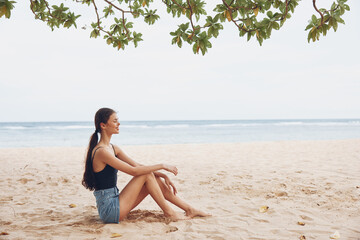 Fototapeta na wymiar nature woman sea travel freedom smile sitting vacation beach alone sand