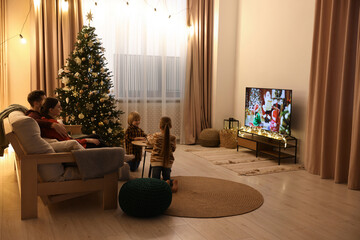 Family watching TV in cosy room. Christmas atmosphere