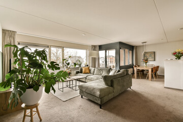a living room with couches and plants in the middle of the room, looking out onto an open patio