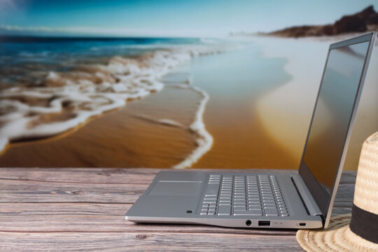 laptop on wooden table in  the beach 