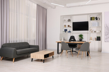 Stylish director's workplace with comfortable furniture and tv zone in room. Interior design