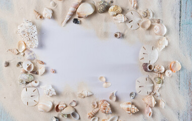 Fototapeta na wymiar Card, sand and seashells on blue vintage wooden planks, frame for summer advertisement 