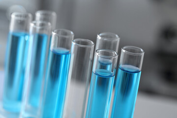 Test tubes with light blue liquid in laboratory, closeup
