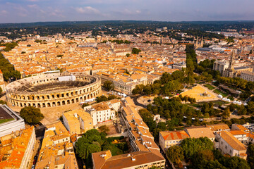 Fototapeta premium Aerial view of Roman amphitheatre on background with cityscape of Nimes. France